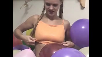 Chick strips and rubs balloons on her tits